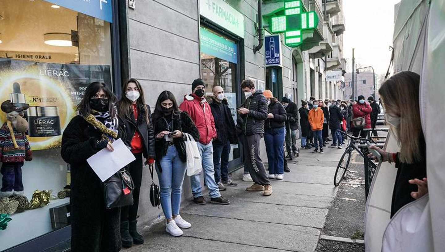 December 2021 | Turin, Italy | Endless queues of people lined up in front of a pharmacy