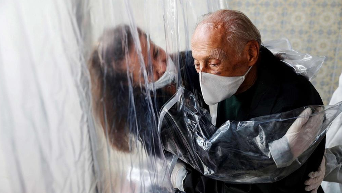noviembre 2020 | Italia | Gente sana abrazándose a través del plástico