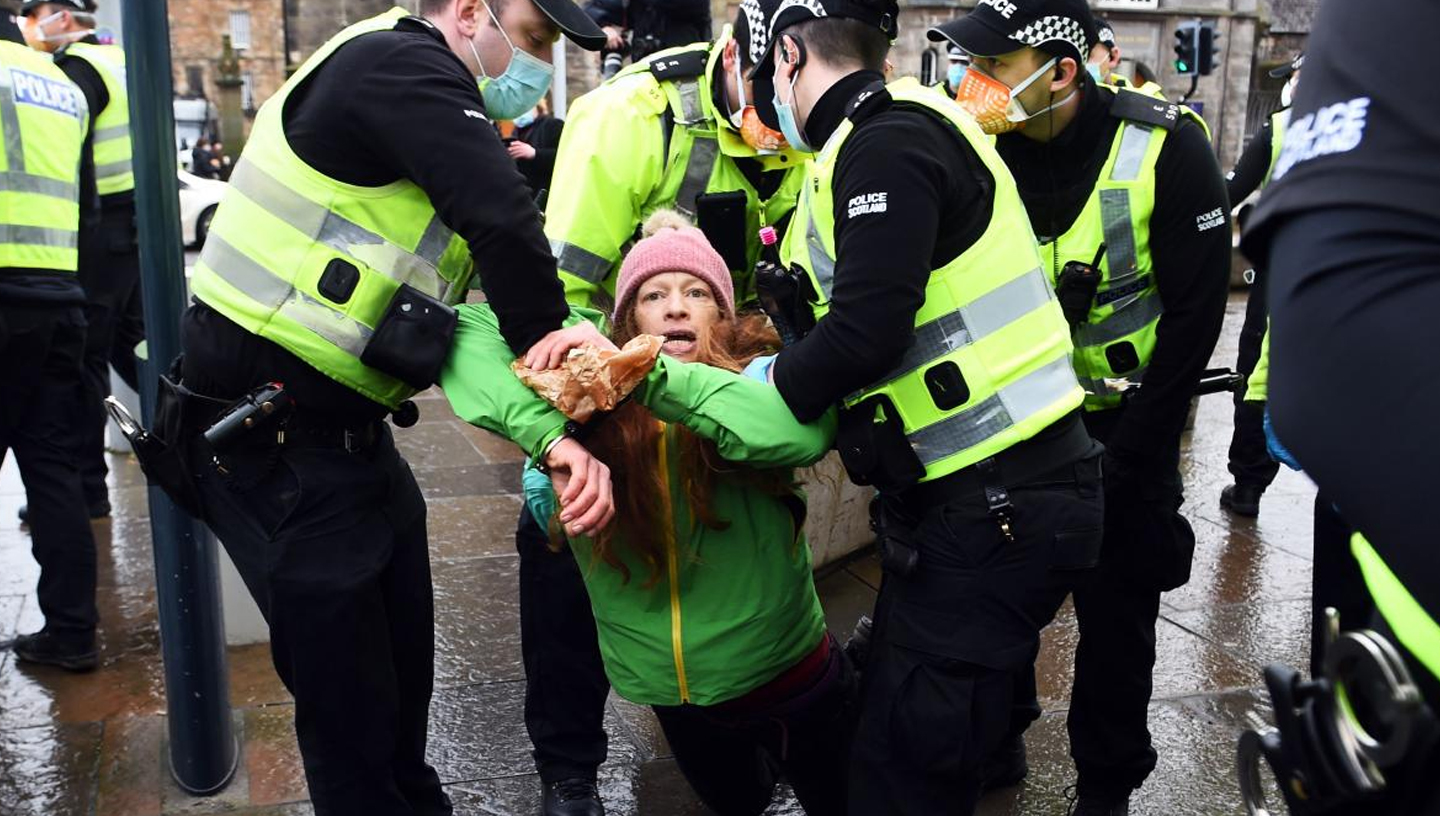 January 12, 2021 | Holyrood, Scotland | Police officers arrest protesters
