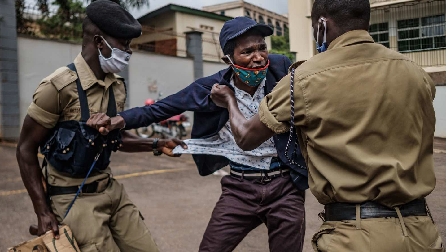 Mai 2020 | Kampala, Uganda | Ein Demonstrant wird von der Polizei während eines Protestes gegen die verstärkte Verteilung von Lebensmitteln durch die Regierung während der Covid-19-Krise festgenommen (Sumy Sadurni / AFP über Getty Images).